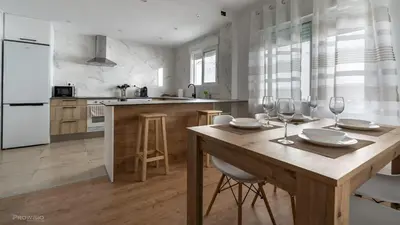 a kitchen with a wooden table with wine glasses on it at Apartamentos Borriana in Burriana