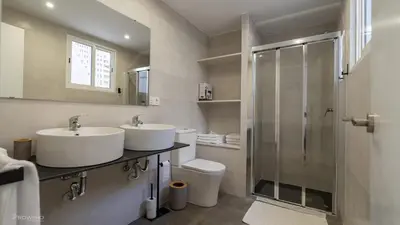 a bathroom with two sinks and a shower at Apartamentos Borriana in Burriana