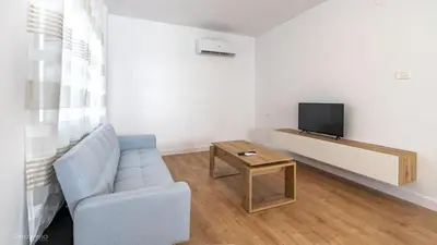 a living room with a blue chair and a tv at Apartamentos Borriana in Burriana