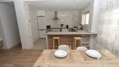 a kitchen with a table and chairs and a counter at Apartamentos Borriana in Burriana