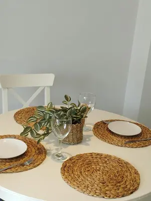 a table with plates and glasses and a plant on it at Apartamento Sunshine Grao in Burriana