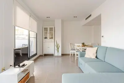 a living room with a blue couch and a tv at Apartamento Sunshine Grao in Burriana
