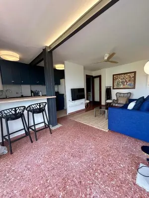 a living room with a blue couch and a kitchen at District Key - Saler, Av Gola Puchol 14 in Valencia