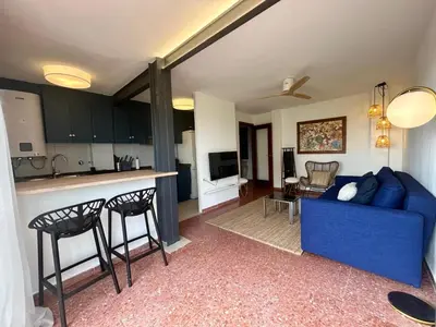 a living room with a blue couch and a kitchen at District Key - Saler, Av Gola Puchol 14 in Valencia
