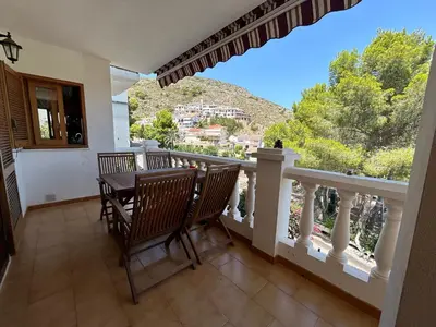 a balcony with a table and chairs and a view at Beauty Garden in Cullera