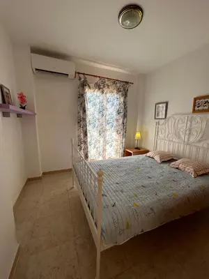 a bedroom with a white bed with a window at Beauty Garden in Cullera