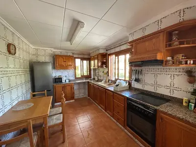 a kitchen with wooden cabinets and a table in it at Beauty Garden in Cullera