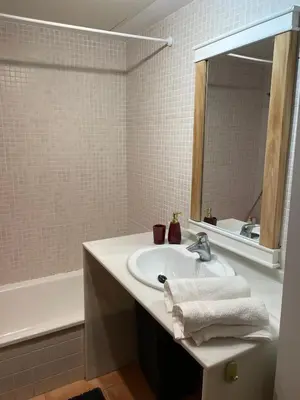 a bathroom with a sink and a mirror and a tub at Sea-Breeze Apartment with Pool & Parking in Cullera