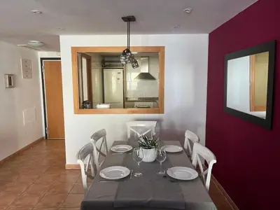 a dining room with a table and chairs at Sea-Breeze Apartment with Pool & Parking in Cullera
