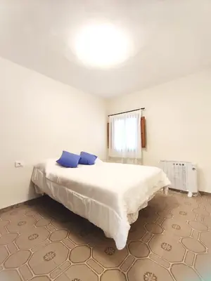 a bedroom with a large white bed with blue pillows at Apartamentos rurales Villamalur in Villamalur