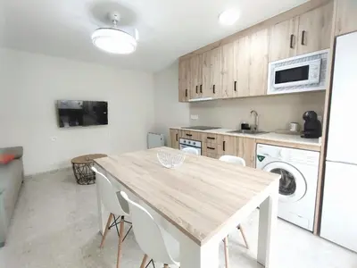 a kitchen with a wooden table and white appliances at Apartamentos rurales Villamalur in Villamalur