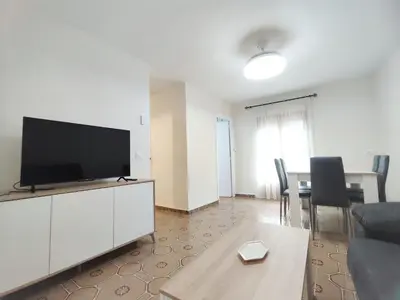 a living room with a tv and a table with chairs at Apartamentos rurales Villamalur in Villamalur