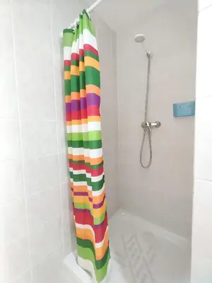 a colorful shower curtain in a bathroom with a tub at Apartamentos rurales Villamalur in Villamalur