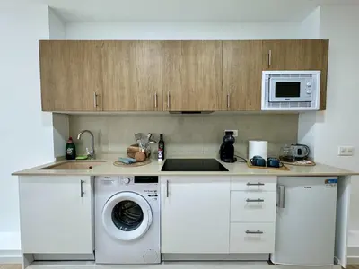a kitchen with a washing machine and a microwave at Cabanyal Apto luminoso y playa in Valencia
