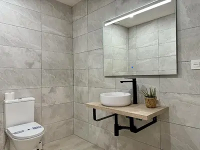 a bathroom with a toilet and a sink and a mirror at Cabanyal Apto luminoso y playa in Valencia