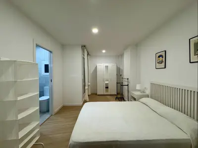 a bedroom with a large bed and a bathroom at Cabanyal Apto luminoso y playa in Valencia