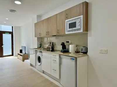 a kitchen with a washing machine and a microwave at Cabanyal Apto luminoso y playa in Valencia