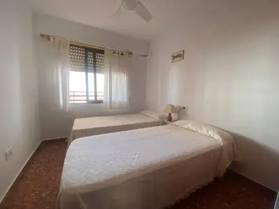 two beds in a white room with a window at Maripatri Solo Familias Serviplaya!!! in Casas Las Basas