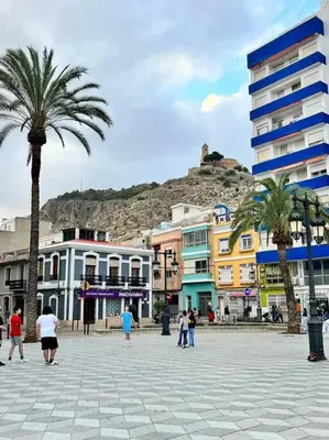 a city with palm trees and a mountain in the background at Casa Abanico in Cullera in Cullera