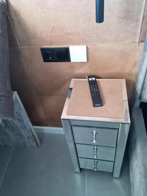 a remote control sitting on top of a nightstand at 