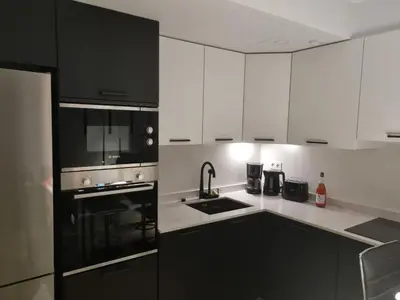 a kitchen with white cabinets and black appliances at 