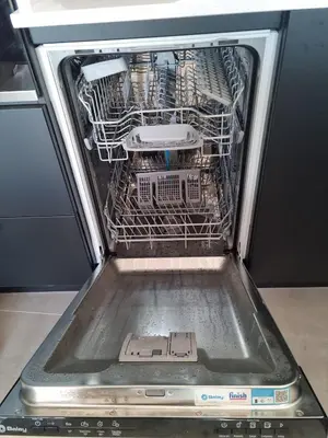 an open dishwasher with a dish rack in it at 