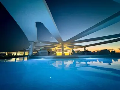 a building with a swimming pool at sunset at 