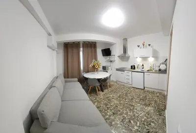 a living room with a couch and a kitchen at Apartamento cerca de la playa in Cullera