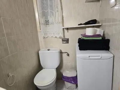 a bathroom with a toilet and a pile of towels at Apartamento cerca de la playa in Cullera