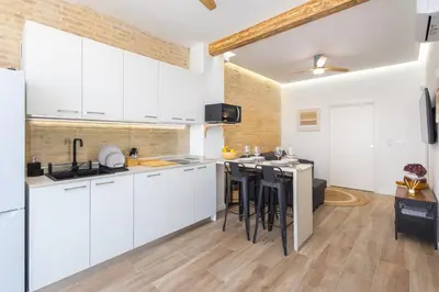 a kitchen with white cabinets and a kitchen island at Moderno, amplio y muy cómodo in Valencia