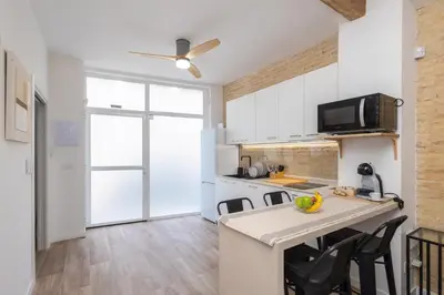 a kitchen with white cabinets and a table with chairs at Moderno, amplio y muy cómodo in Valencia