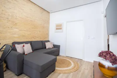 a living room with a gray couch and a brick wall at Moderno, amplio y muy cómodo in Valencia