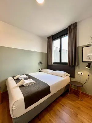 a bedroom with a large bed and a window at Apartamentos de Pradas in Valencia