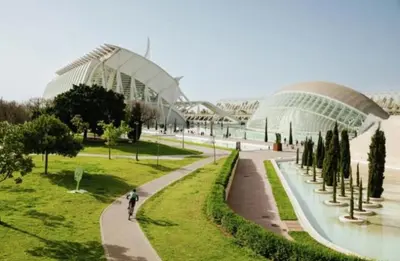 a person riding a bike in a park with a building at Sweet Suites in Valencia