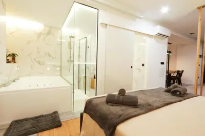 a bedroom with a bed and a bath tub and a shower at Sweet Suites in Valencia