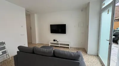 a living room with a couch and a tv on a wall at Cabañal Retreat in Valencia