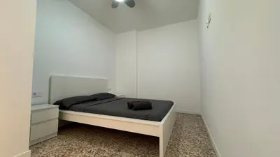 a bedroom with a bed and a white wall at Cabañal Retreat in Valencia