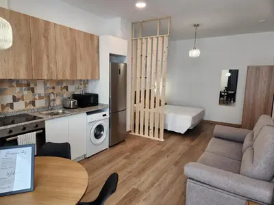 a kitchen and a living room with a couch and a table at Dormavalencia Crónica in Valencia