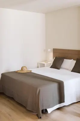 a bedroom with a large white bed with brown sheets at Lindala Natural in Valencia