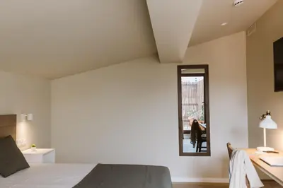 a bedroom with a bed and a desk and a mirror at Lindala Natural in Valencia
