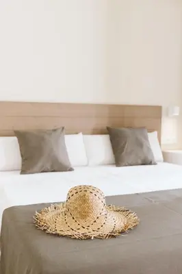 a straw hat sitting on top of a bed at Lindala Natural in Valencia