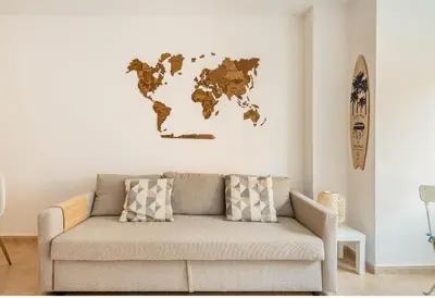 a couch in a living room with a world map on the wall at Lindo y Discreto apartamento playa in Moncófar