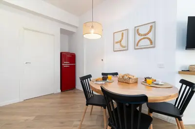 a dining room with a table and chairs and a red refrigerator at Travel Habitat Bioparc Apartments in Valencia
