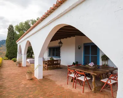 an outdoor patio with a wooden table and chairs at House -Sleeps 8-Natural Pool-Pet Friendly in Artana