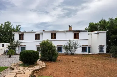 a white house with windows and a yard at House -Sleeps 8-Natural Pool-Pet Friendly in Artana