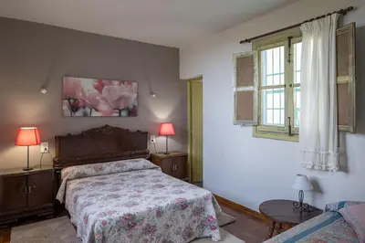 a bedroom with a bed and two lamps and a window at House -Sleeps 8-Natural Pool-Pet Friendly in Artana