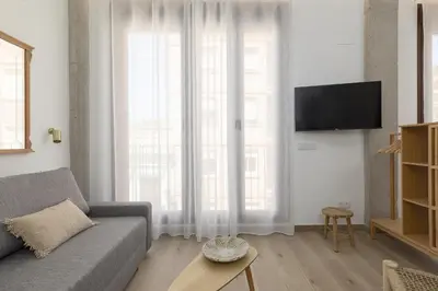a living room with a couch and a large window at ApartUP Ca La Leni Beach V in Valencia