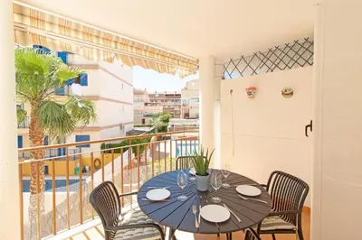 a dining room with a table and chairs and a balcony at Apartamento playa de Canet WIFI in Canet de Berenguer