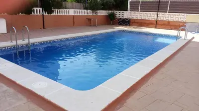 a large swimming pool with blue water at Apartamento playa de Canet WIFI in Canet de Berenguer