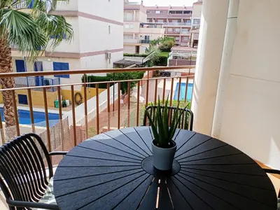 a black table with an umbrella on a balcony at Apartamento playa de Canet WIFI in Canet de Berenguer